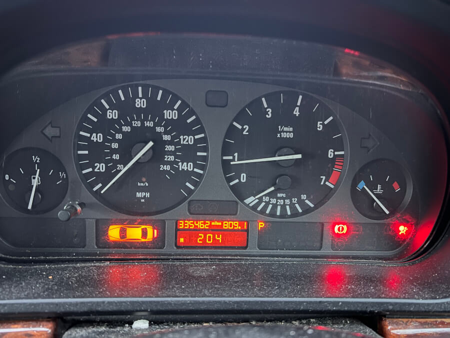 The dashboard of Andrew Scott’s BMW displays a mileage of 335,462, highlighting the car’s extensive use and its symbolic connection to his entrepreneurial journey.